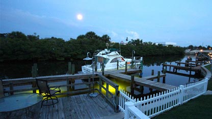 Night time view of the underwater fish lights and boat dock at Suntan Terrace Beach Resort